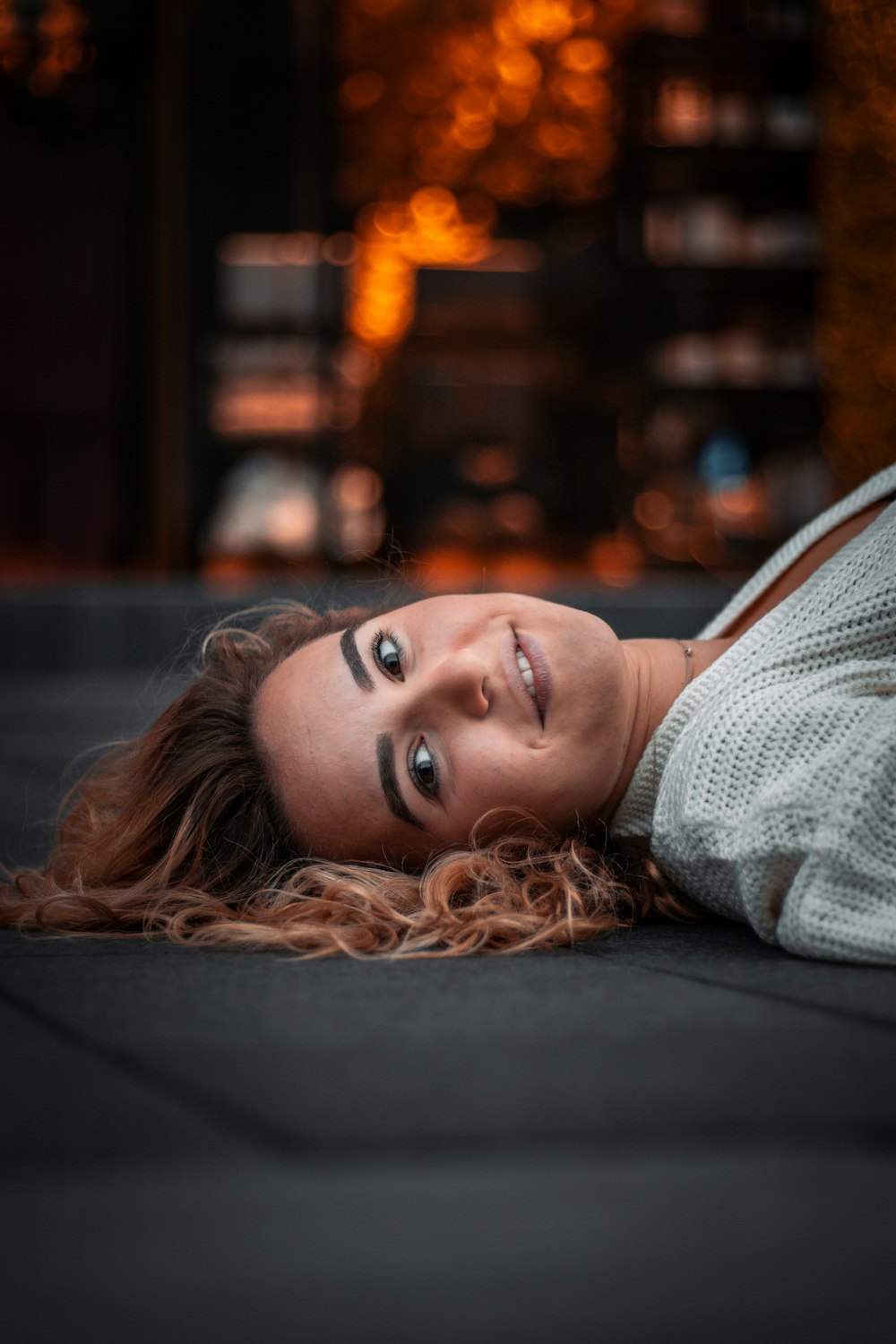 woman in white shirt lying on black textile