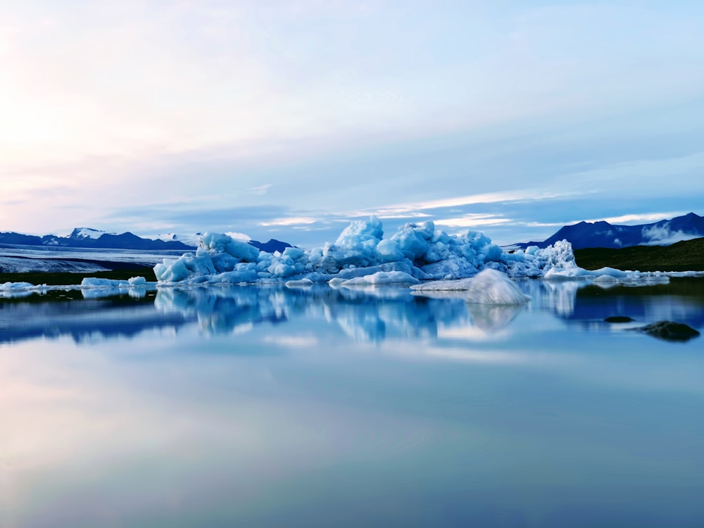 snow covered mountain near body of water during daytime