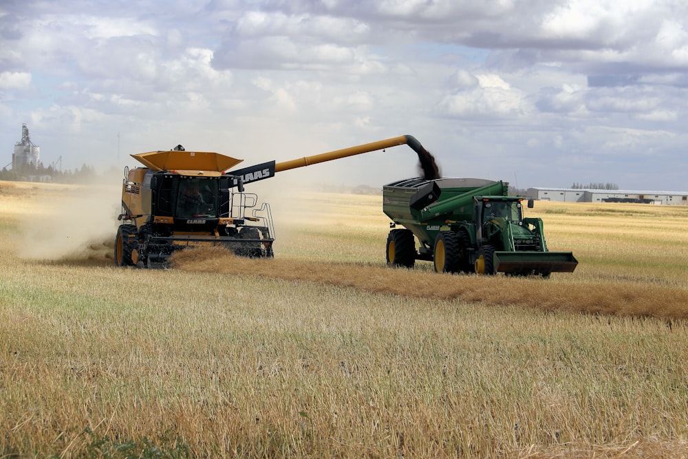 green and yellow heavy equipment on brown field during daytime