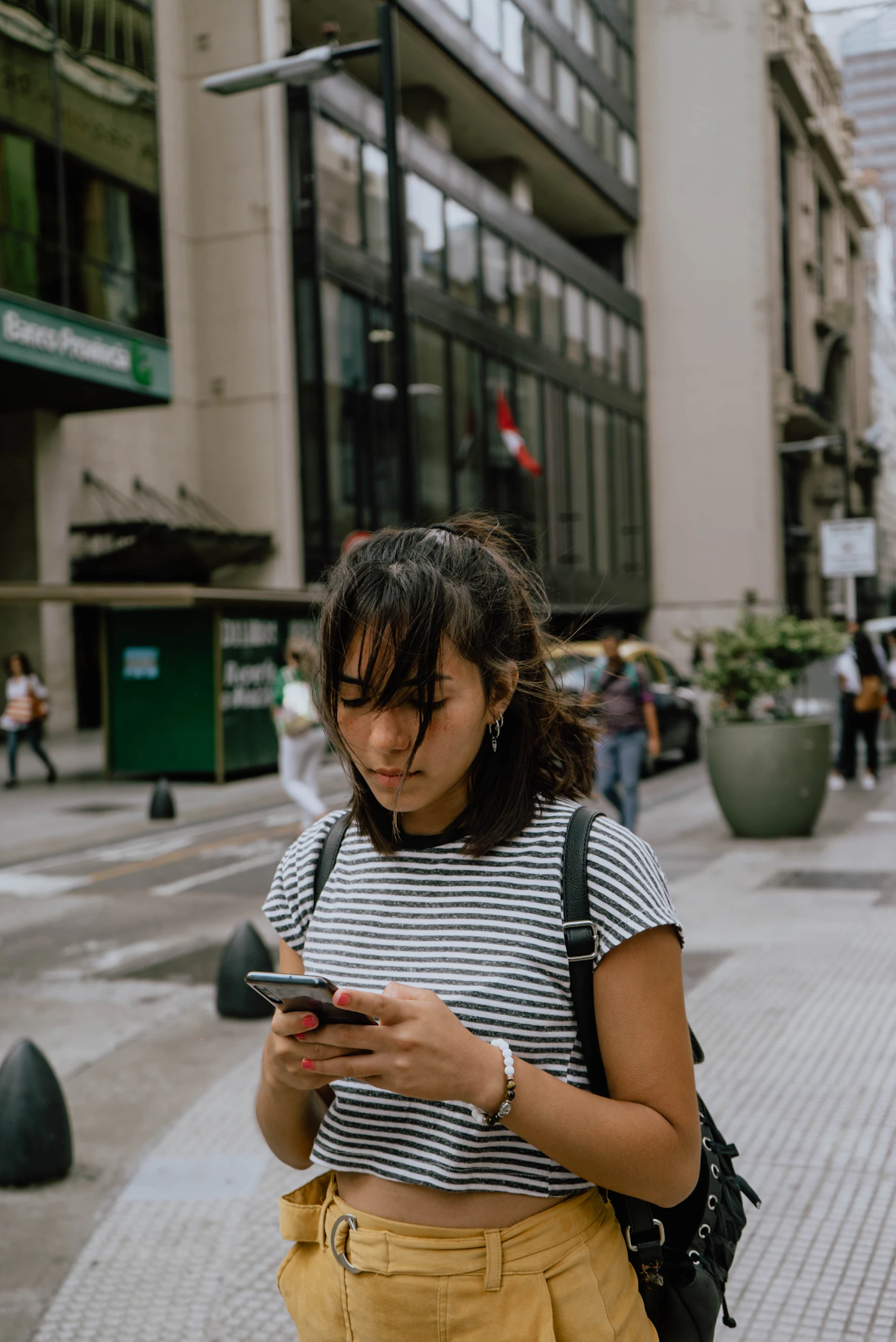 A traveller checking her phone on a city street