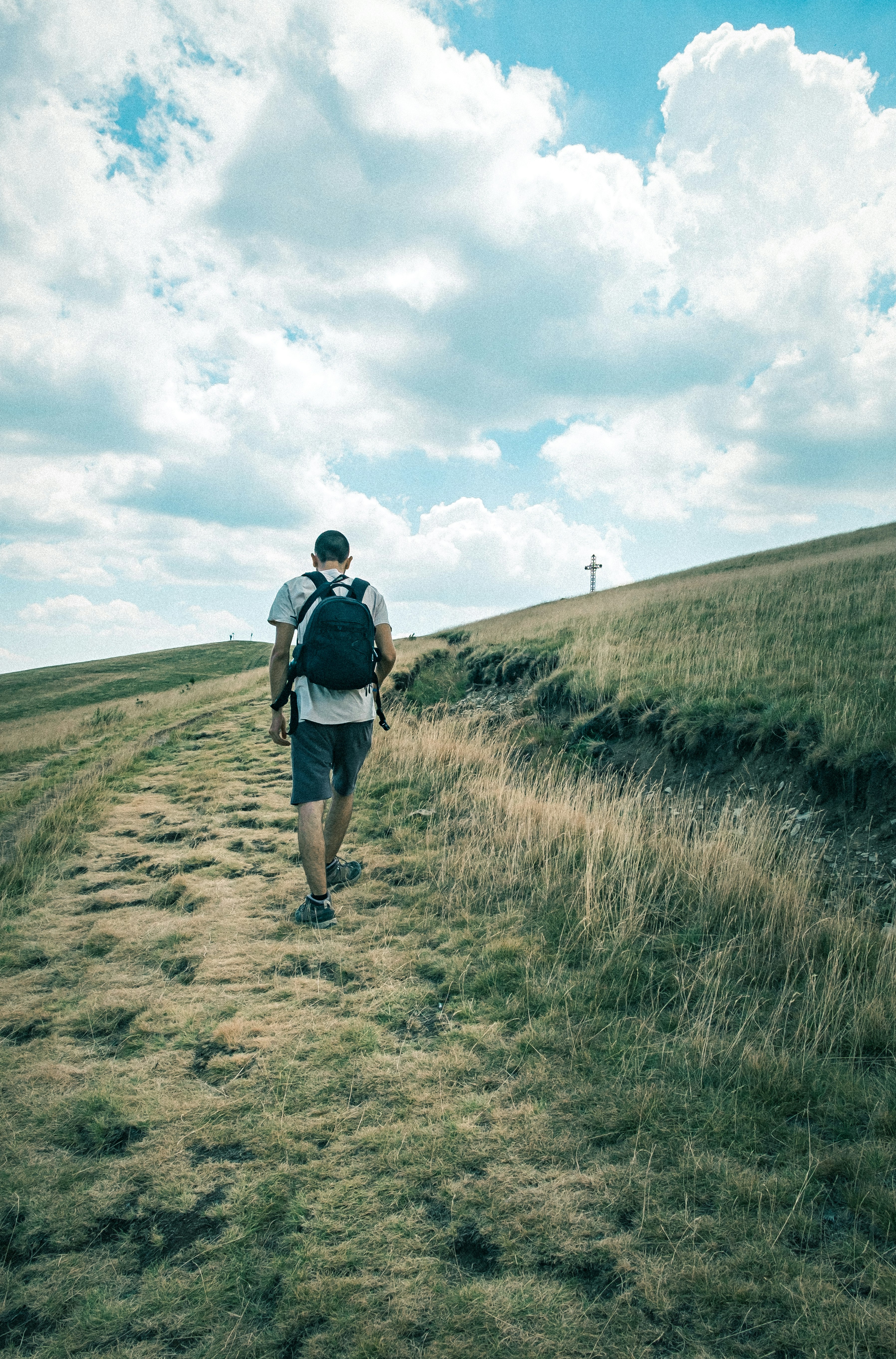 man in black jacket walking on brown field during daytime