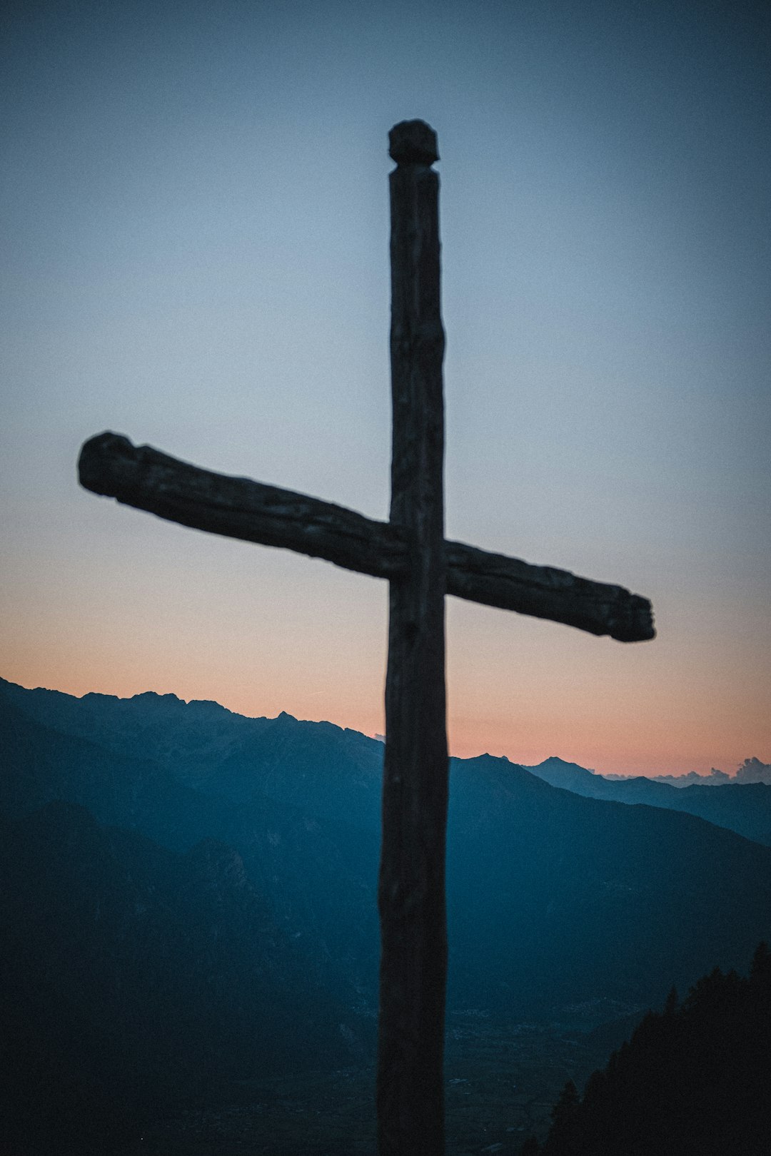brown wooden cross on top of mountain during daytime