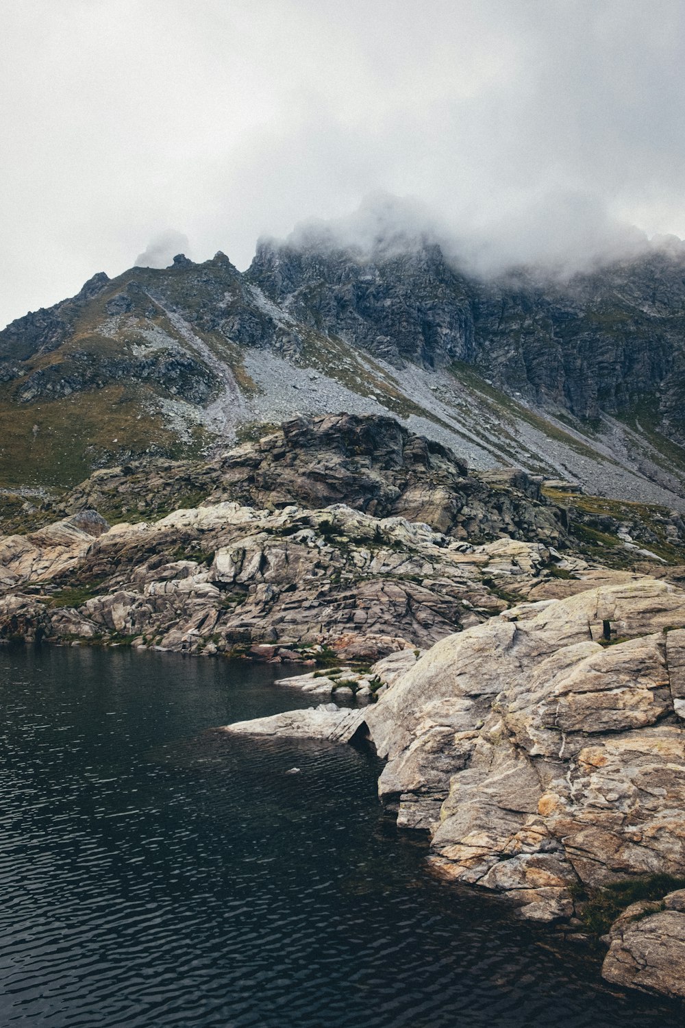 brown and gray rocky mountain beside body of water during daytime