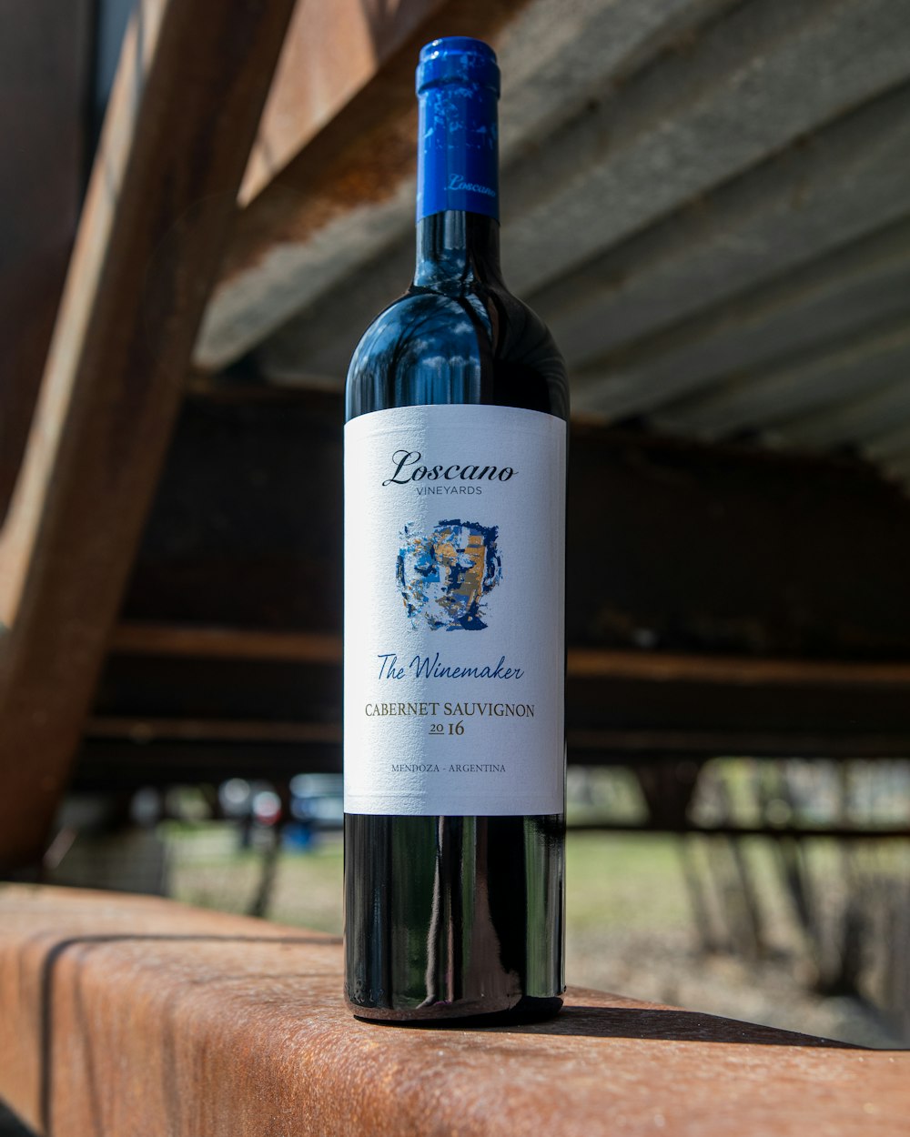 a bottle of wine sitting on top of a wooden table