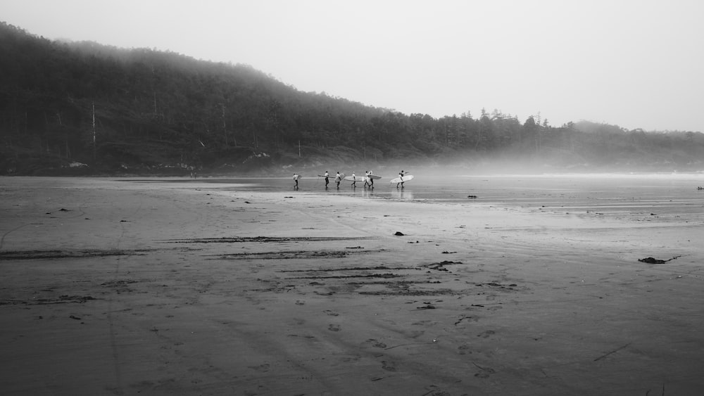 grayscale photo of people on beach