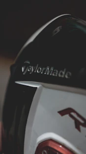 A close-up of a sleek new golf club head gleaming under soft light.