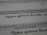 A close-up view of typeface samples printed on a sheet of paper. The text is in different styles and fonts, highlighting decorative and serif characteristics. The paper appears slightly angled, emphasizing the artistic nature of typography.
