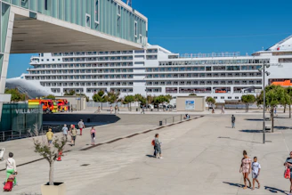 A panoramic view of a cruise ship docked near a bustling Mediterranean port.