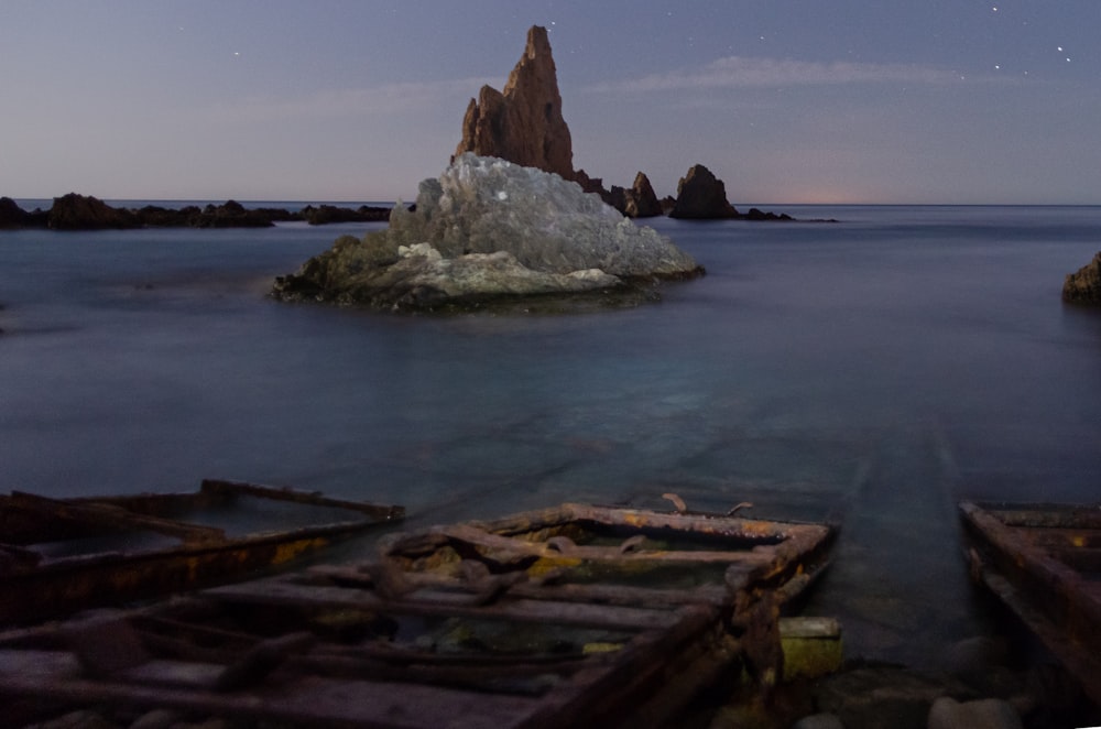 brown and gray rock formation on body of water during daytime