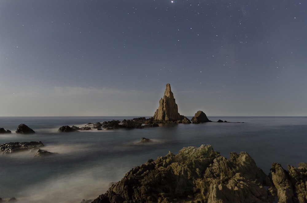 brown rock formation on sea shore during night time