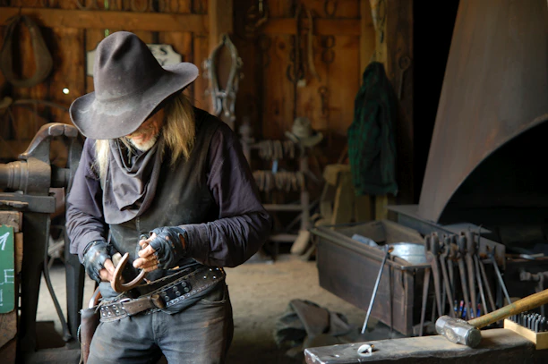 A cinematic close-up of a master craftsman hand-stitching a premium leather hat band in a dimly lit workshop.