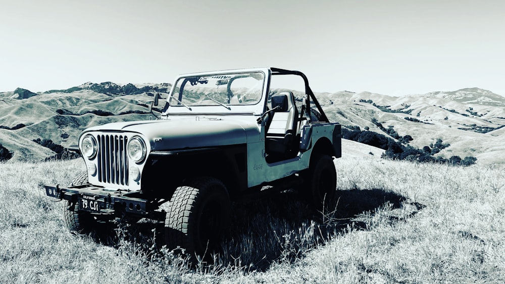 white and black jeep wrangler on gray field during daytime