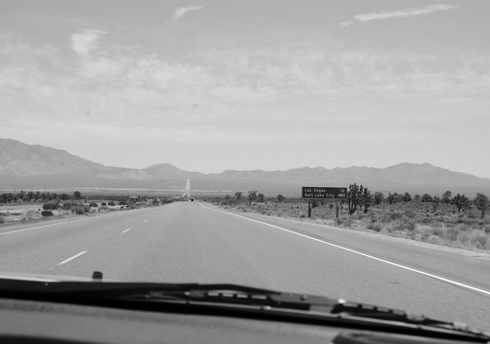 grayscale photo of road near mountain