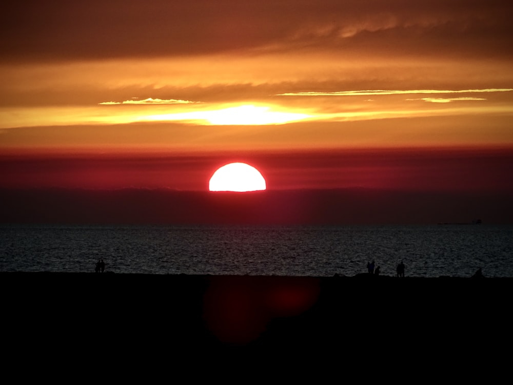 silhouette of people on beach during sunset