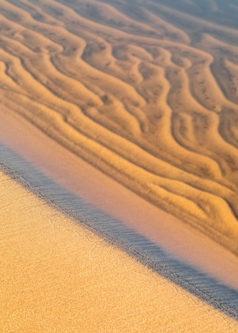 brown sand with footprints during daytime