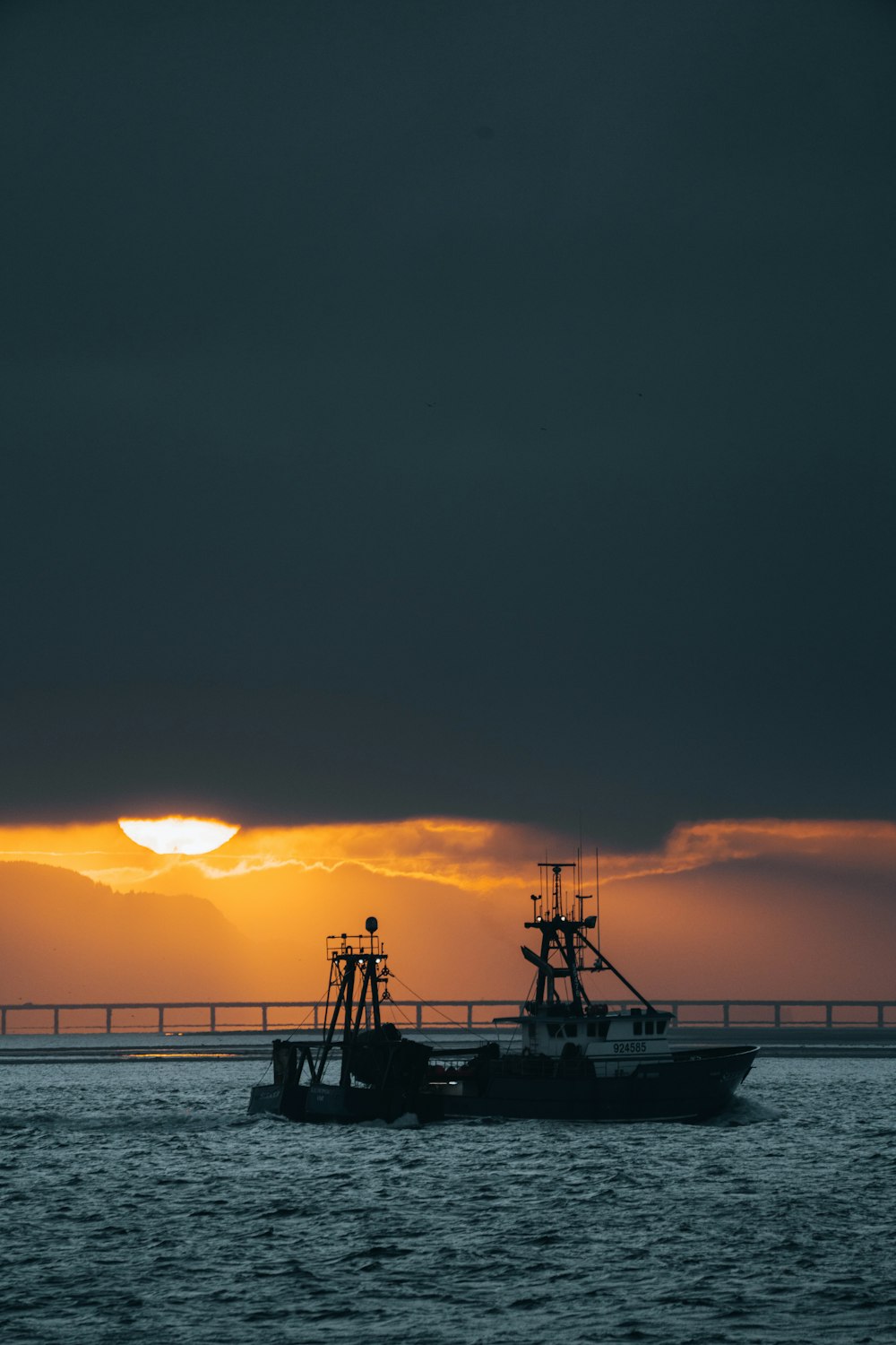 silhouette of boat on sea during sunset