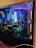 A well-organized and illuminated computer interior showcasing components like a GeForce GTX graphics card, illuminated RAM sticks, and other hardware. The setup features colorful LED lighting that enhances the aesthetic of the components and creates a vibrant visual appeal.
