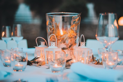 Cozy table setting with olive leaf centerpiece and softly glowing candle