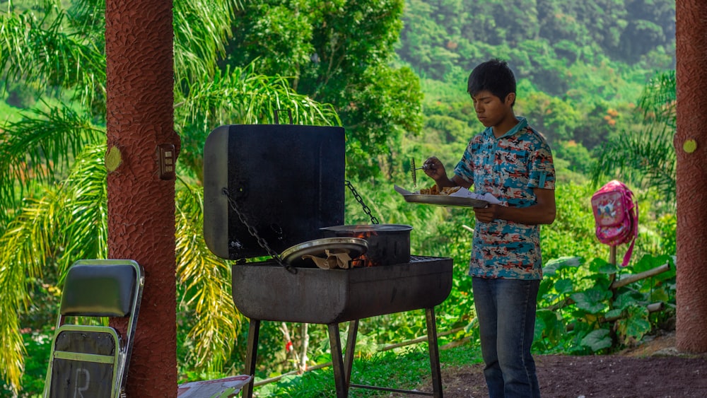 man in blue and red floral button up shirt cooking