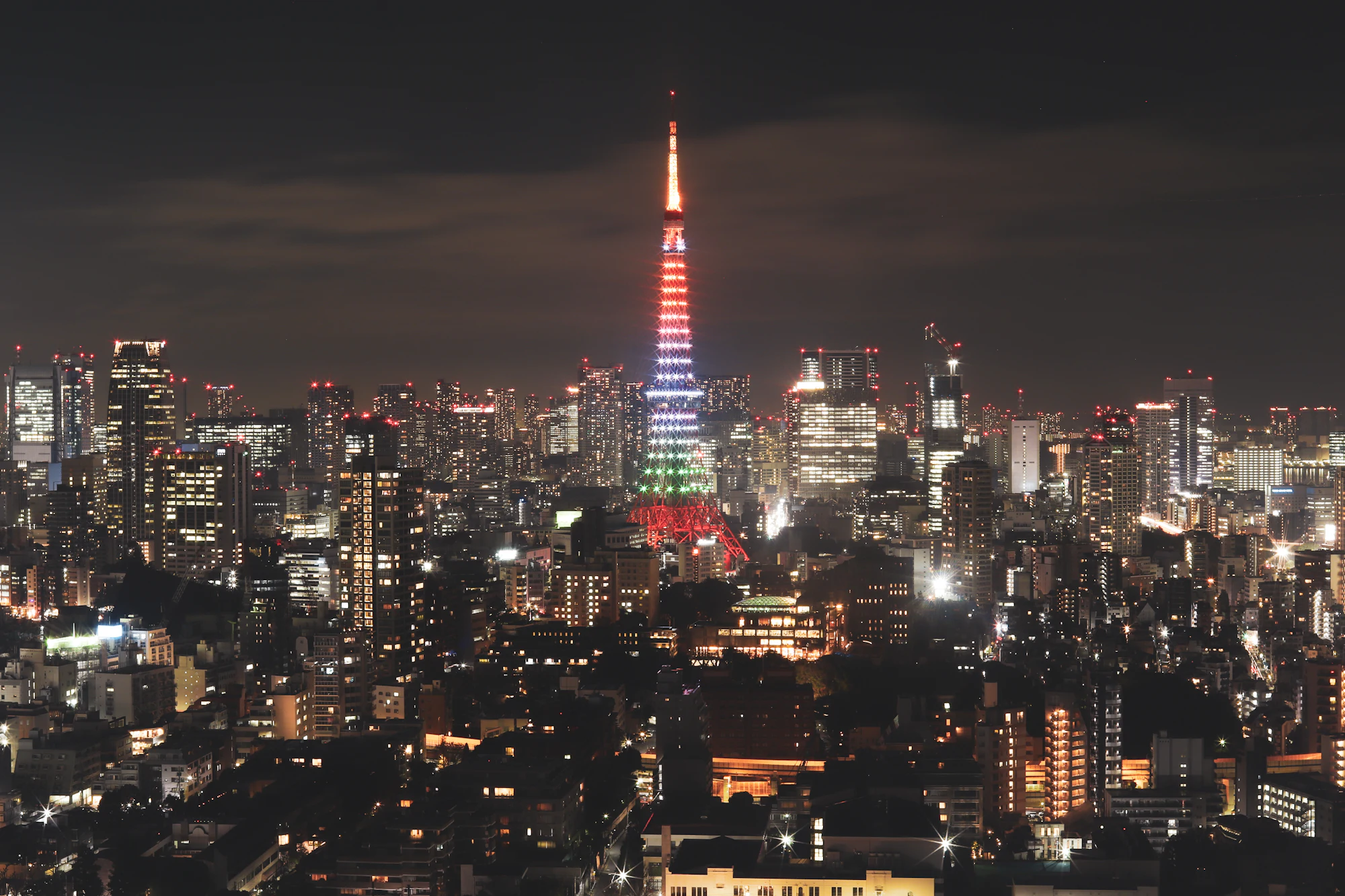 Tokyo Tower illuminated above the city skyline at night.