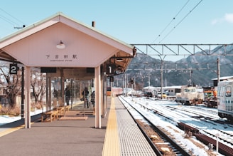 brown wooden bench near train rail during daytime