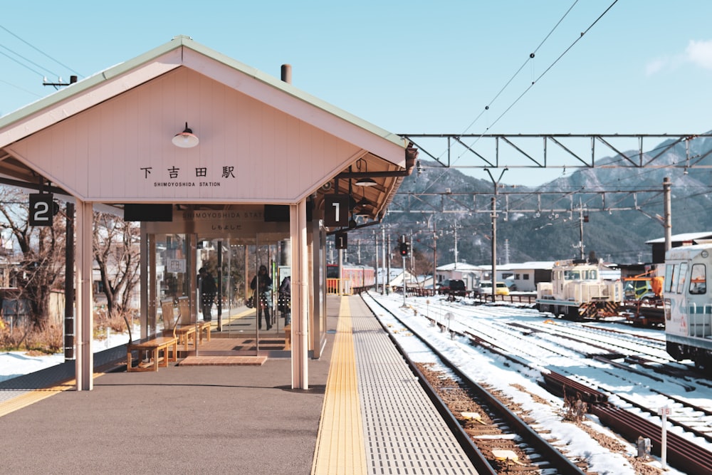 brown wooden bench near train rail during daytime