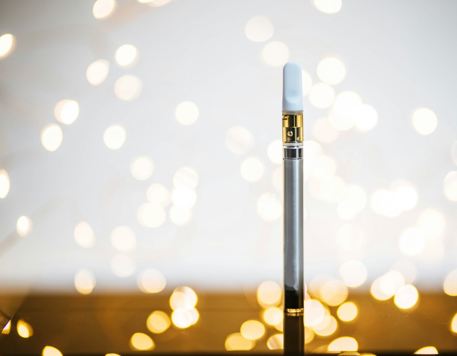 Clinical product shot of a black-and-white vape device on a dark background, no person present.
