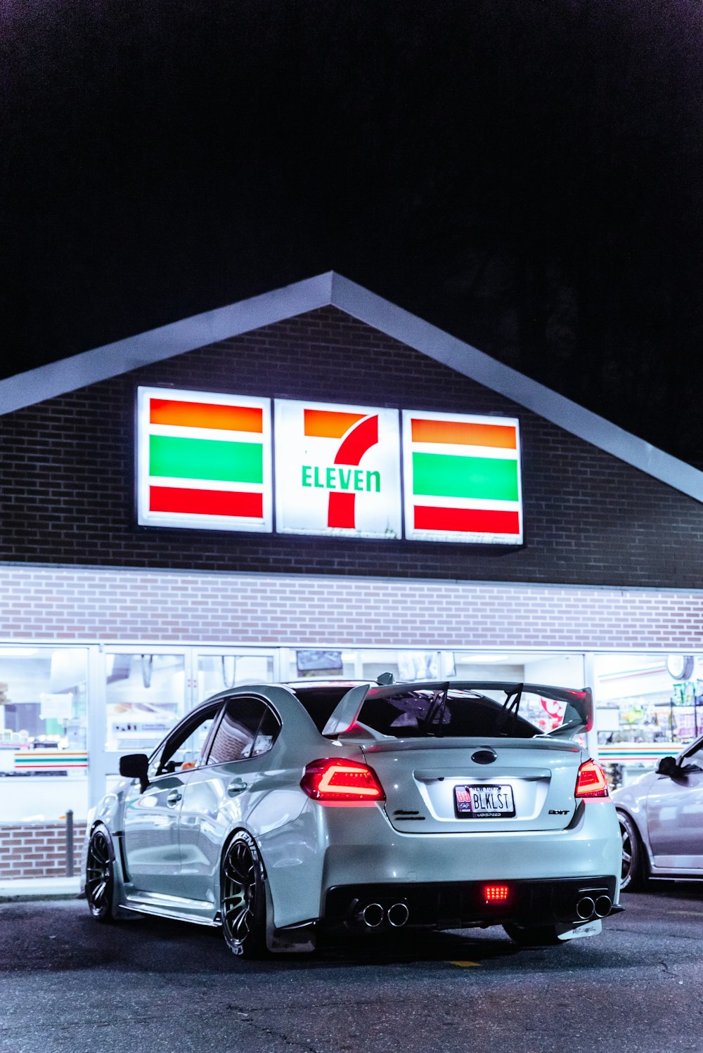 cars parked in front of white and red building during nighttime