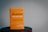 A book with a bright orange cover resting on a wooden surface. The title 'Beautiful Resistance' is prominently displayed in bold, stylized font, and the author's name, Jon Tyson, is indicated. The background is plain with a subtle, muted tone.