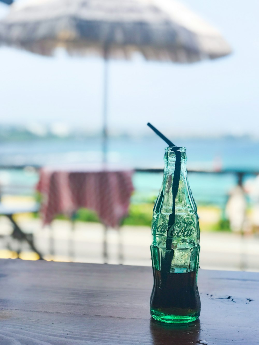 green glass bottle on brown wooden table