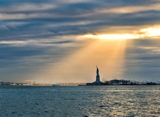 silhouette of statue of liberty during sunset