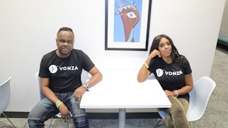 Elegant portrait of the Voe Business founders in a modern office setting with a dark, luxurious background.