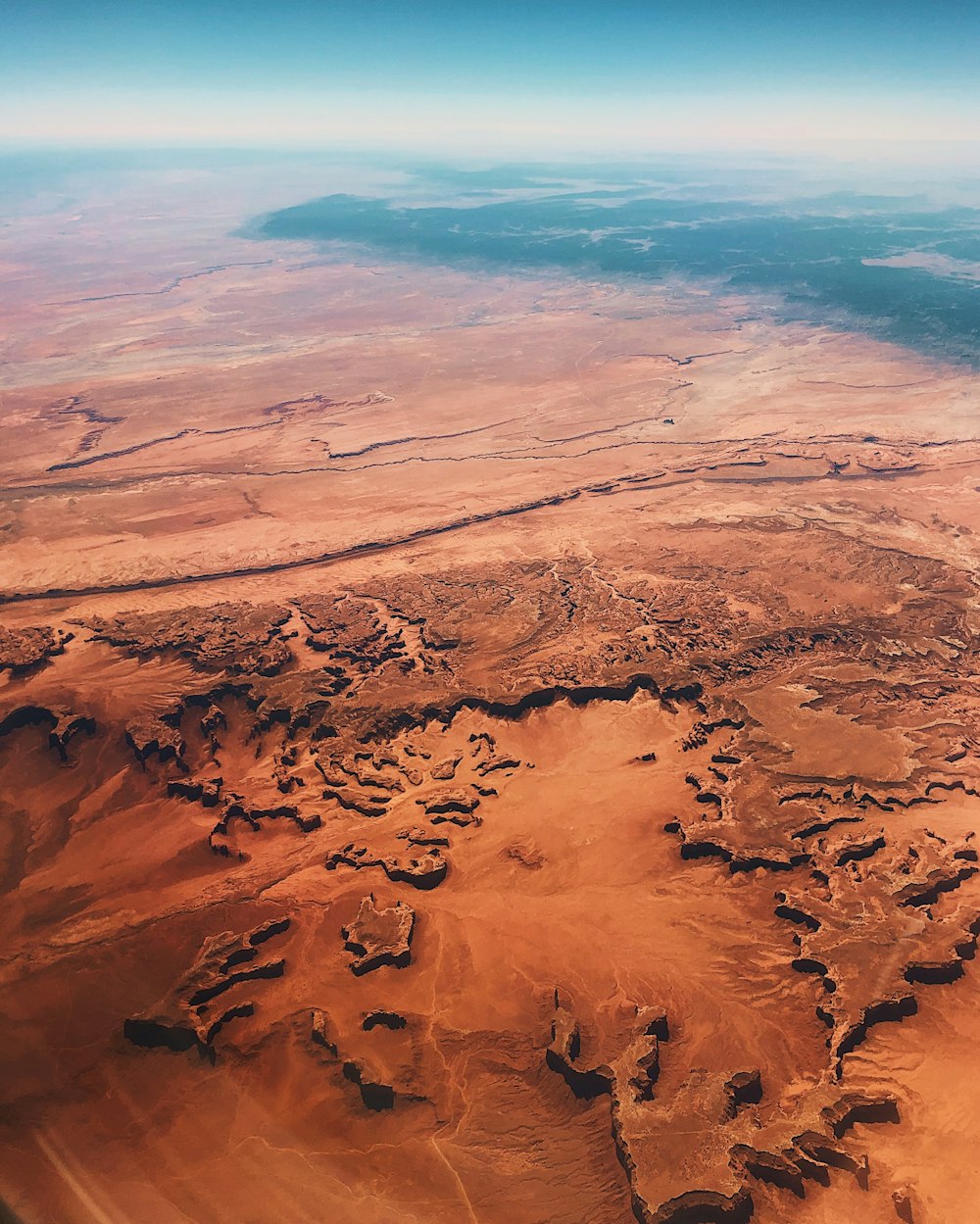 an aerial view of a desert with a river running through it