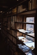 A dimly lit room filled with vintage maps and scattered research papers.