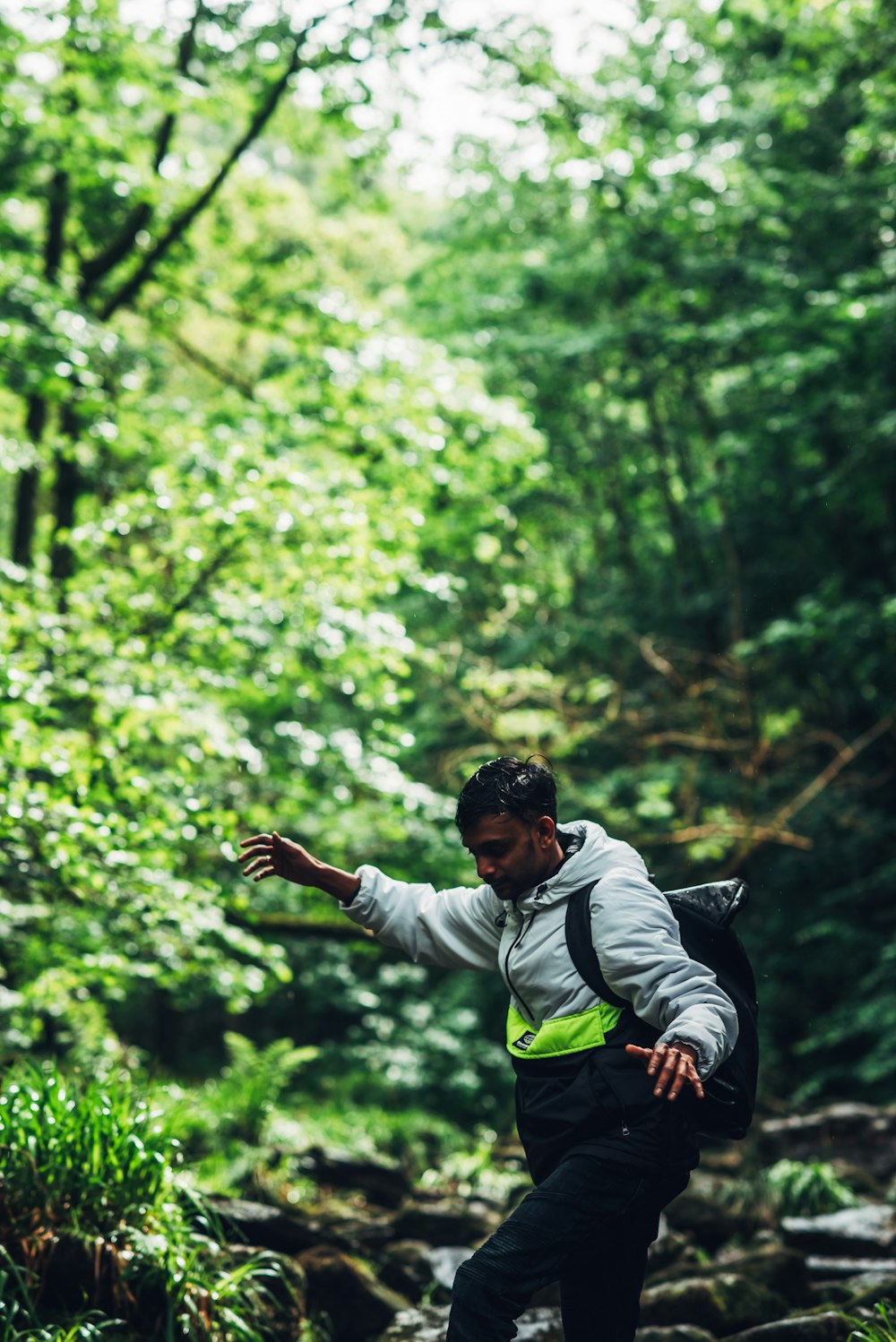 man in green and white jacket jumping on air during daytime