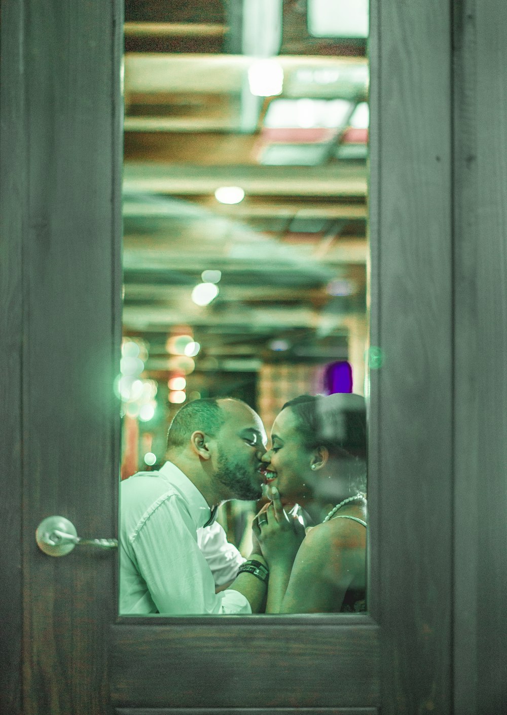 man in white suit kissing woman in white dress