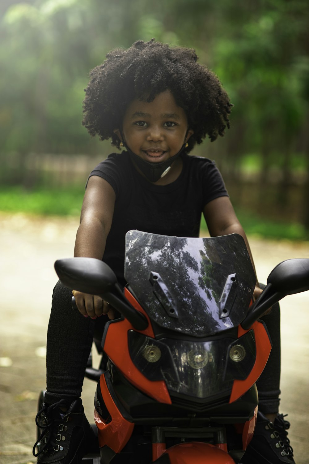 girl in black crew neck t-shirt riding red motorcycle