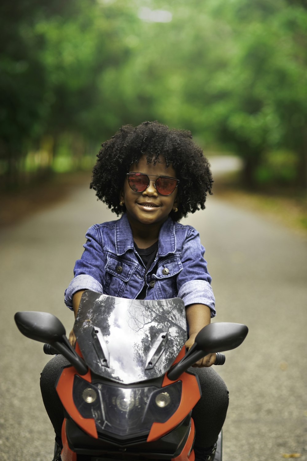 woman in blue denim jacket sitting on motorcycle