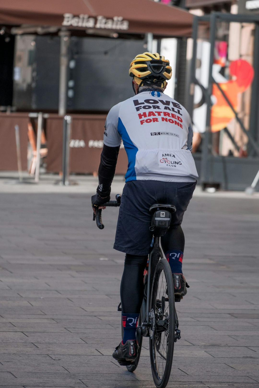 man in blue and white long sleeve shirt riding on bicycle