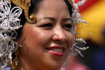 Close-up portrait of a village head smiling warmly in traditional attire.