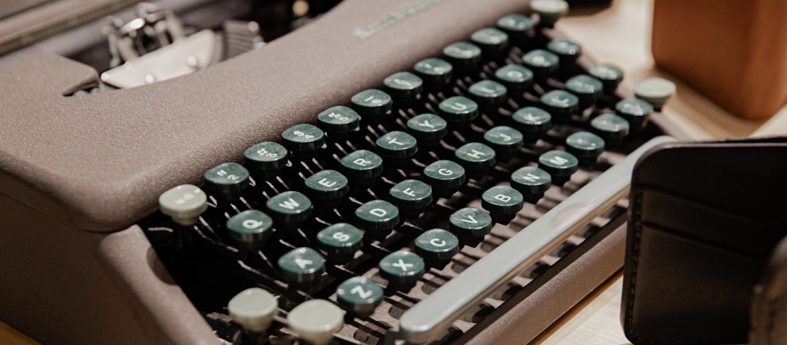 black typewriter on brown wooden table