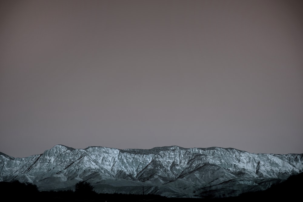 snow covered mountain under gray sky