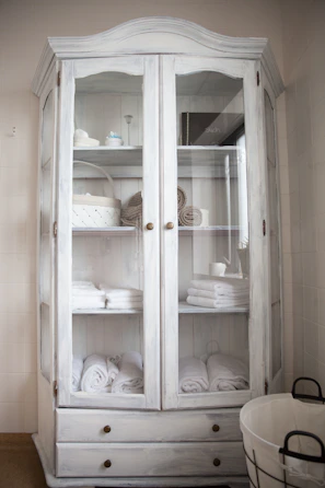 An over-door organizer hanging on a bathroom door, filled with toiletries and small towels.