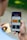 A person holding a smartphone displaying a colorful app interface with categories such as 'Supermarkt' and 'Opticien'. The person is also holding a credit card in the other hand.