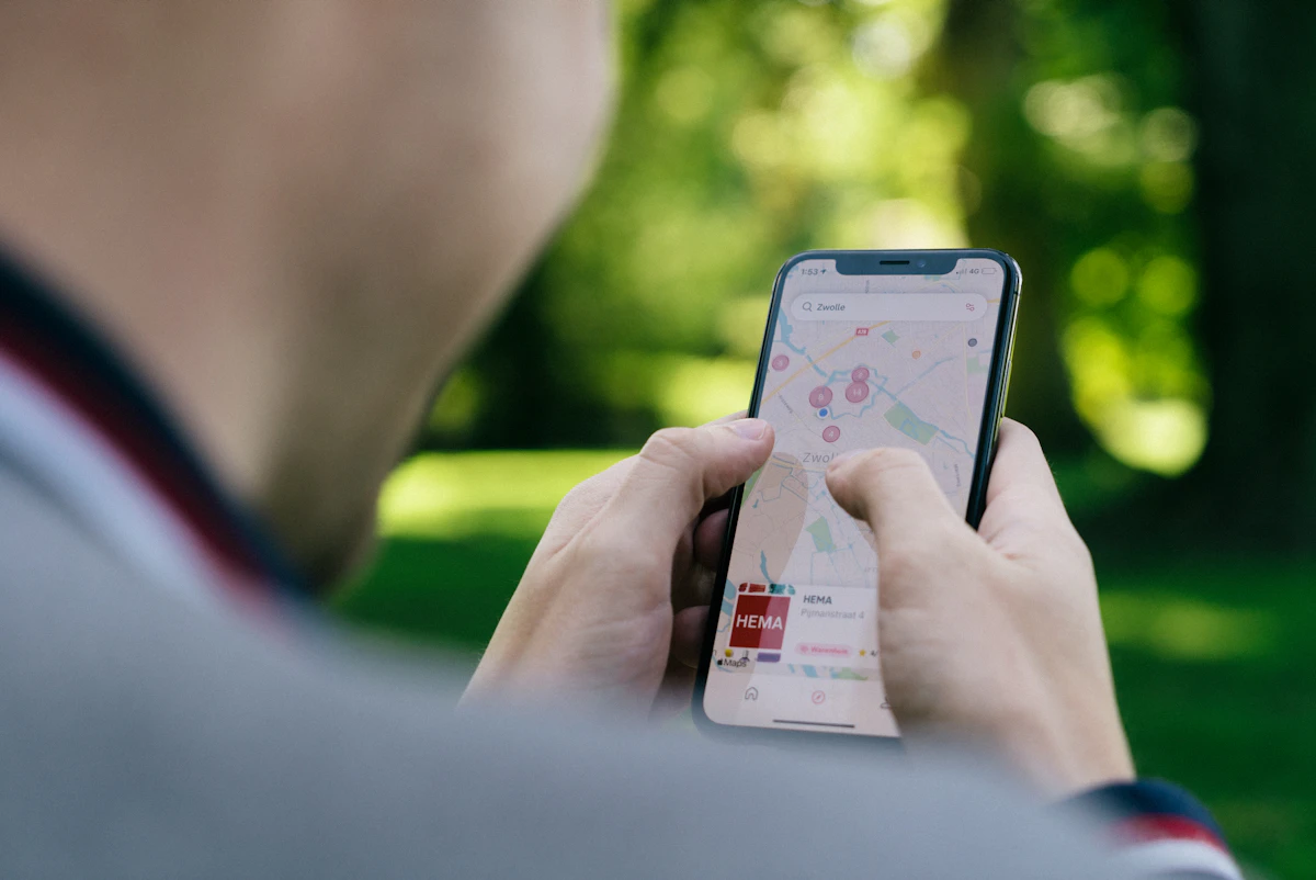 Persona sosteniendo un teléfono móvil con una aplicación de mapas abierta