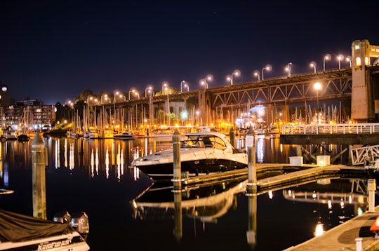 white and black boat on dock during night time in False Creek Canada