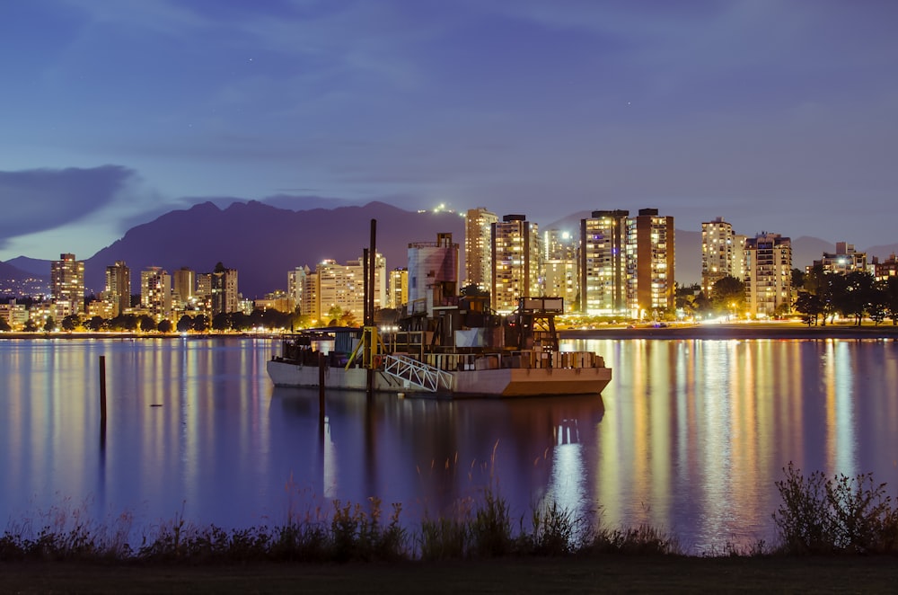 city skyline across body of water during night time