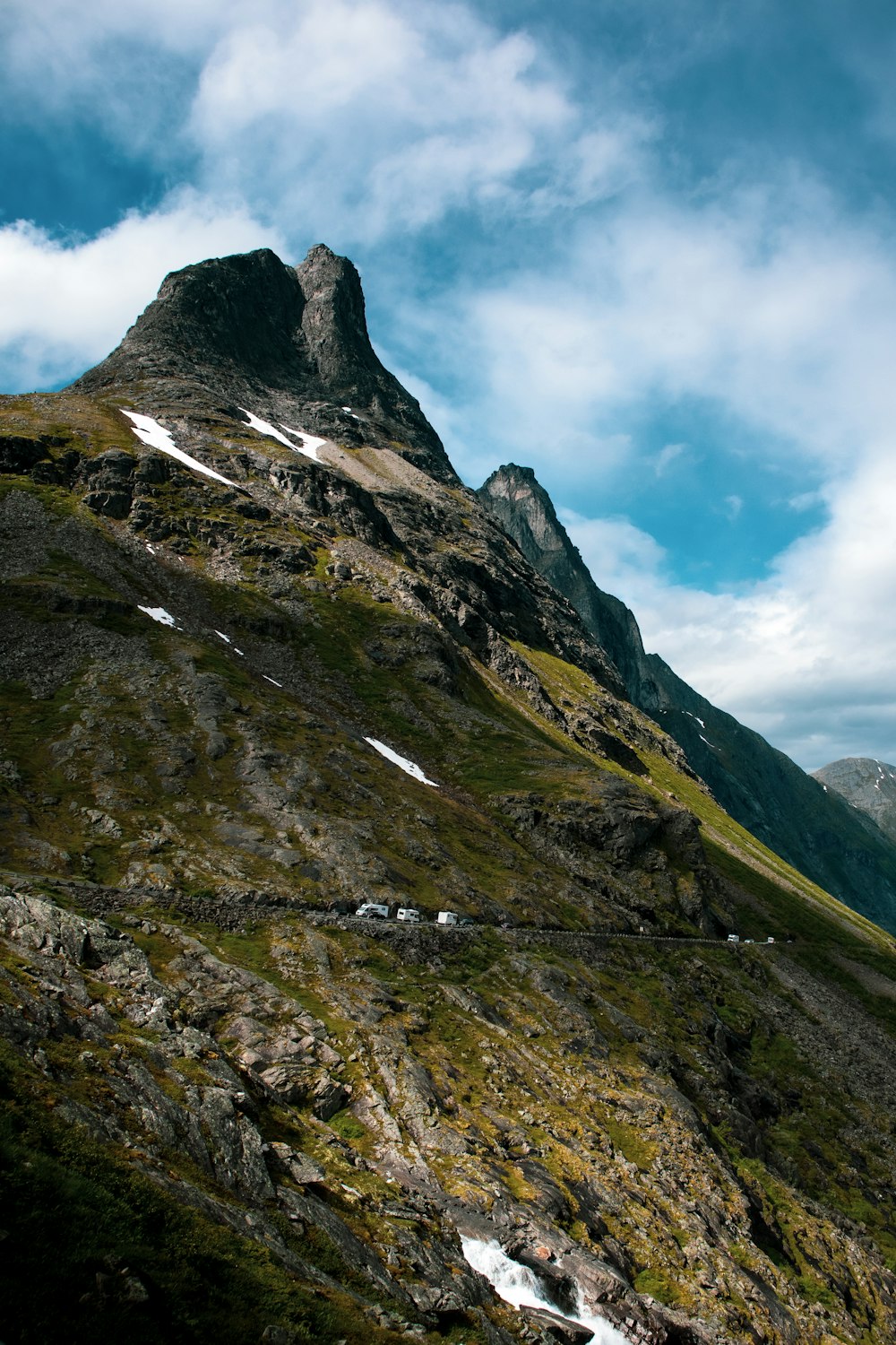 brown and green mountain under white clouds and blue sky during daytime