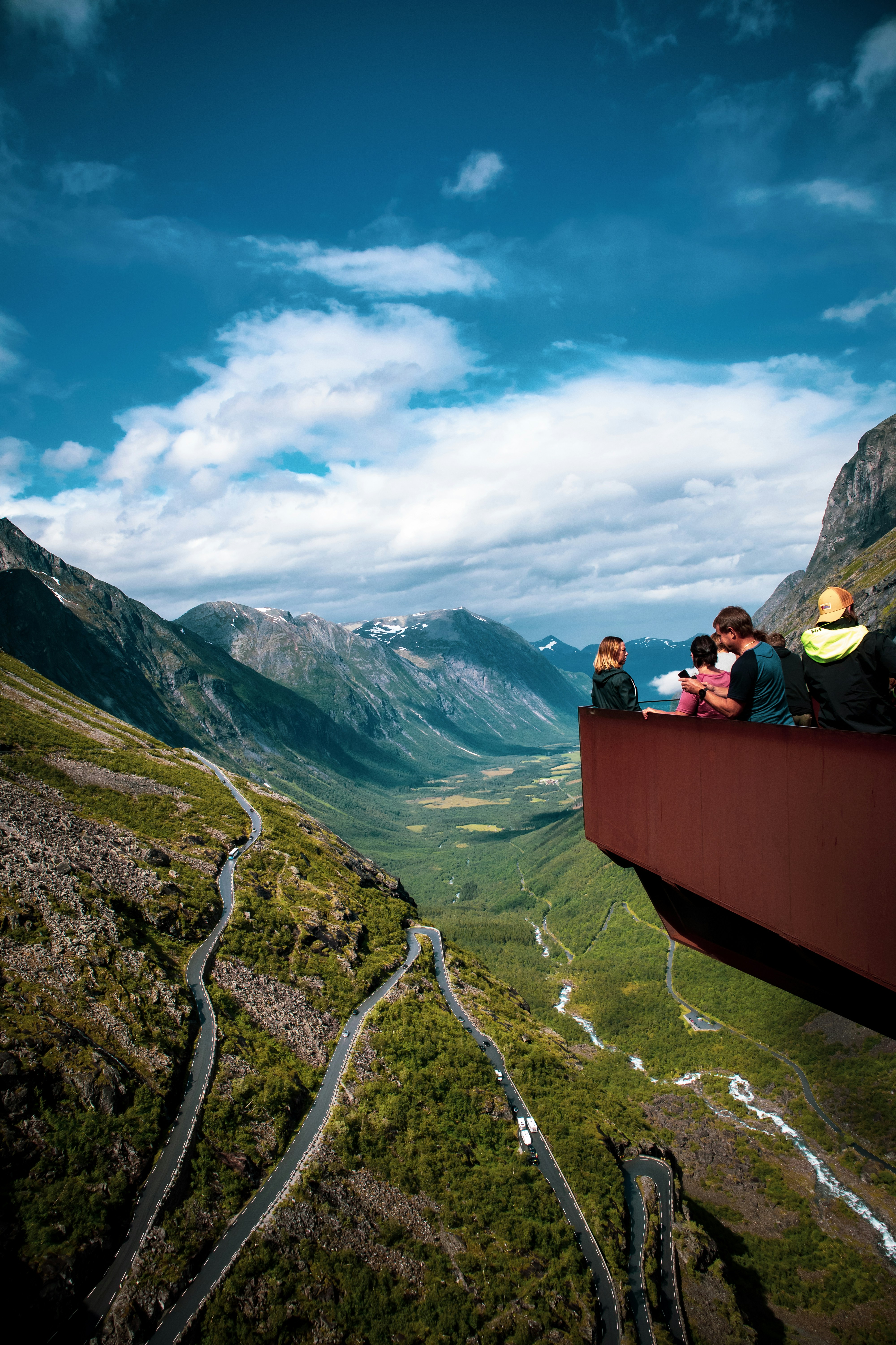 people sitting on brown wooden bench on mountain during daytime