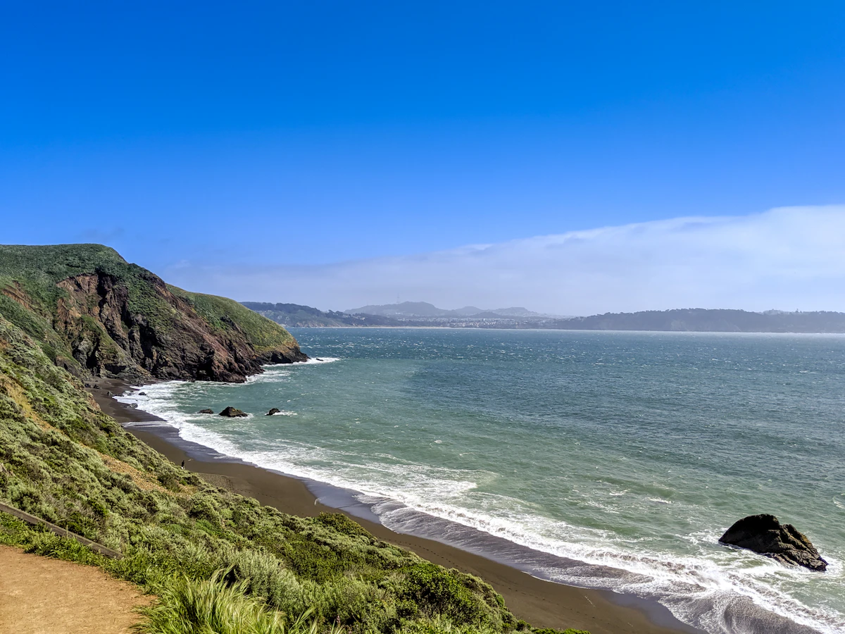 A grassy bluff above Rodeo Beach in the Marin Headlands, with cliffs and surf below